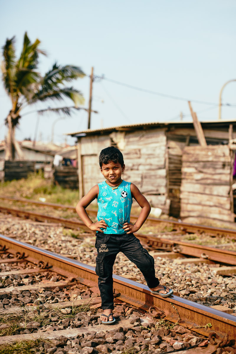 Ganzkörperportrait eines stolzen kleinen Jungen auf den Gleisen nahe Colombo/ Sri Lanka, 2019