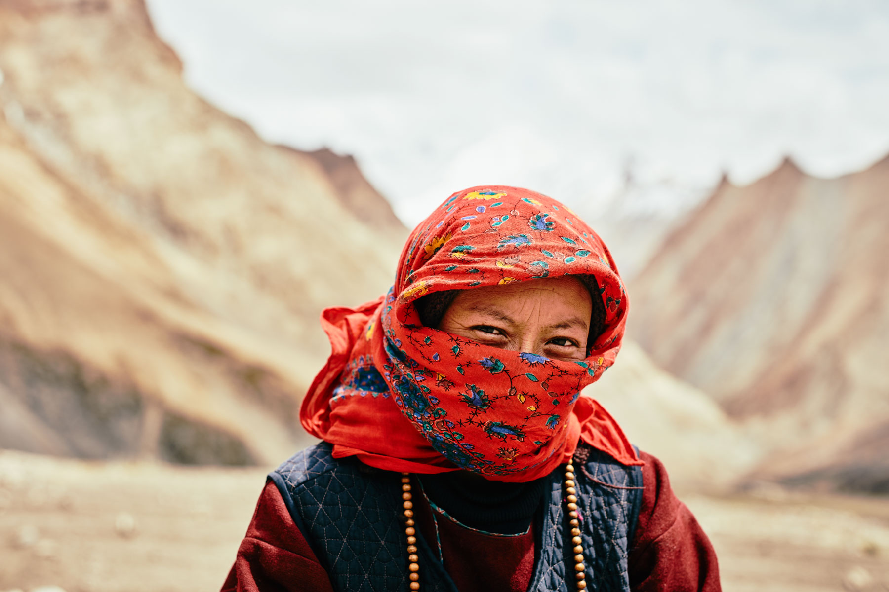 Portrait von Frau mit rotem Kopftuch in Gongma/ Ladakh/ Indien, 2018